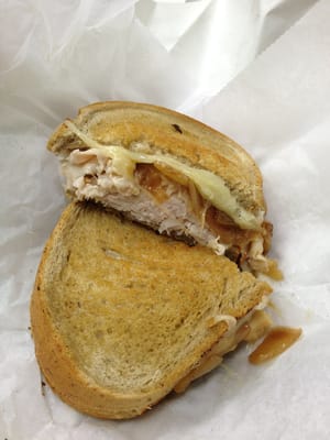 Hot turkey sandwich provolone cheese on grilled rye bread.