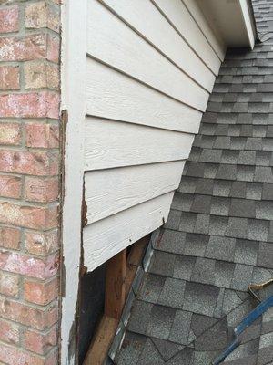 Water damaged siding caused by tree debris build-up in valley.