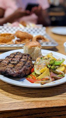 Steak, veggies and onion rings.