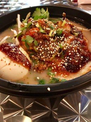 Udon noodles with tonkotsu broth, pork chashu, bamboo sprouts, cilantro, edamame, kimchi, tonkatsu sauce, and the spicy uchi sauce