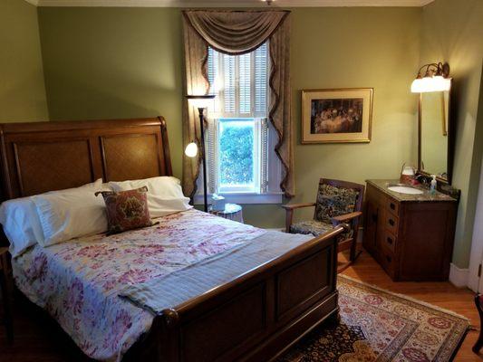 Downstairs bedroom. Queen sized bed, sink and fireplace.