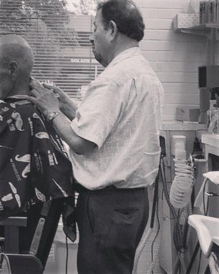 International Barbershop Owner Auggie doing a haircut on a client.