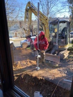 Giovanni holding a helical pile prior to install.