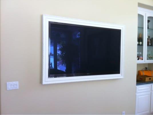 Wall mounted tv with picture frame around it