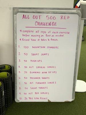 Whiteboard with a title All Out 500 rep Challenge and ten exercises.