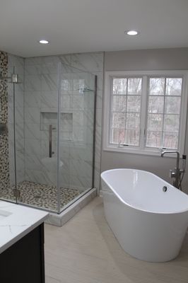 Free standing Tub installed with frameless shower door and pebble stone install in shower floor. Remodeled done in Ellicott city, MD.