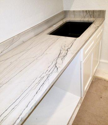 Macaubas White Quartzite 3 cm. With black undermounted sink for a laundry.