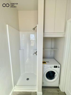 Spacious bathroom with standup tall shower with subway tile design, washer dryer combo, and water heater cabinet with 19gal water heater.