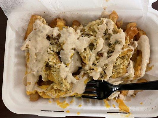 Crabby Cone - split crab cake on top of French fries, covered with sauce, and cheese on the bottom