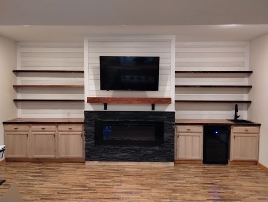 Finished fireplace, genstone facade, floating shelves, counter tops and mantle made from 100 year old reclaimed heart pine, Shiplap walls.