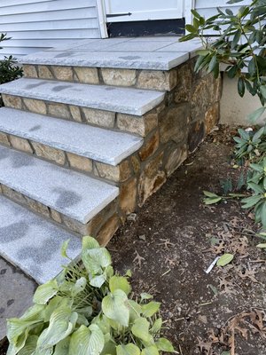 After picture of stairs with new salt and pepper granite cappings and landing area complete with a new veneer facing and sides