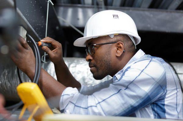 Electrician in Cedar Park installing an electrical outlet