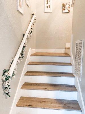 Vinyl plank stairs with white risers. The stair skirt was built by Chris Chubbs, a local contractor.