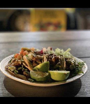 4 tacos de asada with cilantro , red salsa , guacamole limes & ravanos on the side