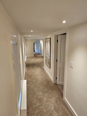 Beautifully lit hallway via indirect light using gimbal fixtures to direct the light to wash off the walls