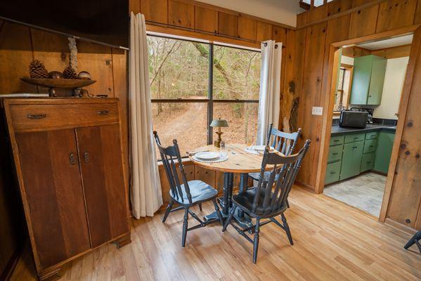 The dining area of the Treehouse looks out over the fire pit and entrance to the cabin.