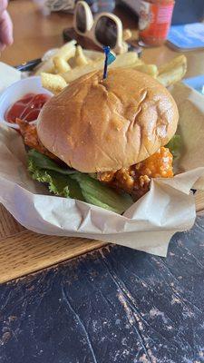 Hot honey chicken buffalo chicken strip sandwich with fries.