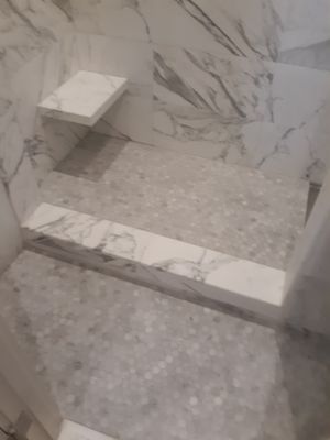 Marble shower walls installed no lippage perfectly straight.  Shower floor in mosaic tile. Mud job properly  pitched to drain