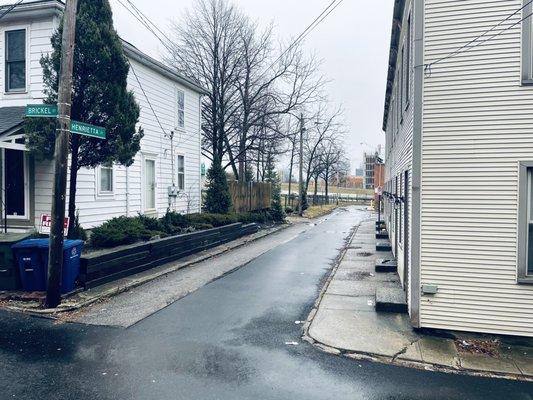 View from front of "luxury rental" of multi-unit housing, vacant property and dirty streets.