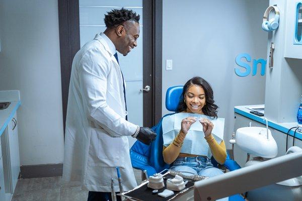 Dr. A showing a patient clear aligners at Smile Design Dental Studio in New York