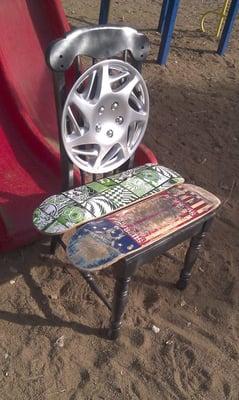 Skateboard Chair from Trash As Art designed using and old chair, hubcap, and skateboards.