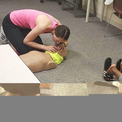 Student learning how to give breaths using a pocket mask.