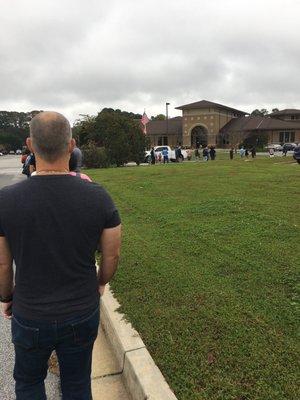 The line of people standing in the street, which stretches all the way around the bldg.