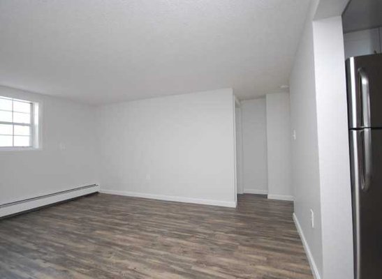 Wood flooring extends from the kitchen to the bright and sunny living room and into the hallway.