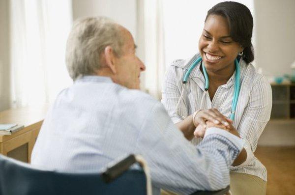 The caregiver is checking vitals.