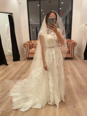 Dress after alterations, at the bridal shop trying on veils