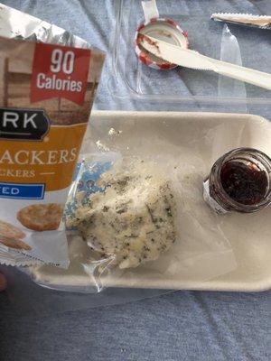 Herb cheese, rice crackers, raspberry jam, knife, and hand wipe. (Picnic box)