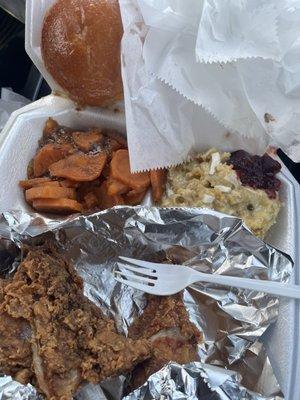 Fried chicken, dressing with gravy and cranberry sauce, sweet potatoes, and a roll.