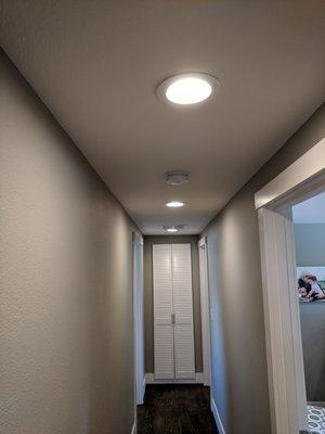 Newly installed recessed lighting down a hallway.