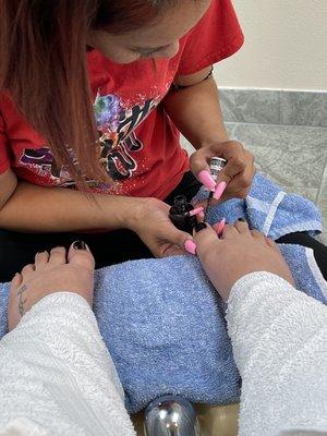 Nail technician and polished toes