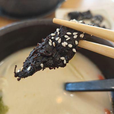 Chinese Miao Style Beef appetizer. Basically, a savory blackened beef jerky coated in sesame seeds