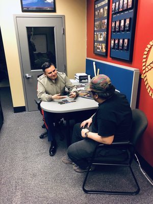 Staff Sergeant Portillo sitting with a interested young man listening to his options