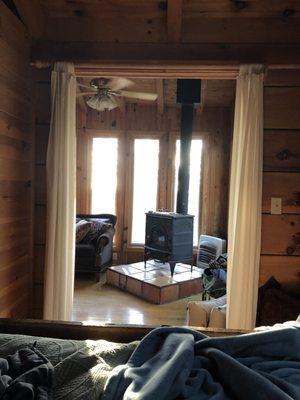 View of wood burning stove and sunrise from the bed