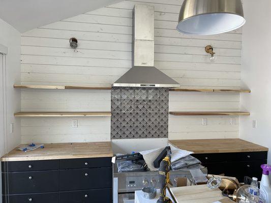 Shiplap wall, floating cedar shelves backsplash and stove top