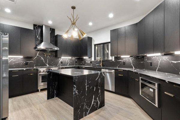 Espresso European style cabinets and black quartz countertop, plus full backsplash