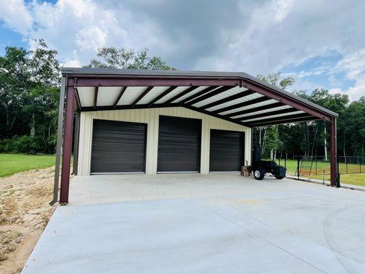 Metal building with 3 roll top doors.