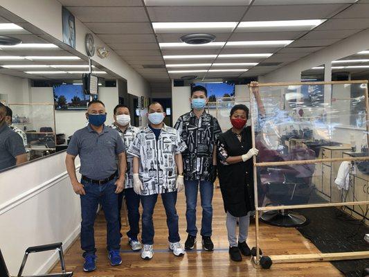 Tam and team with masks and gloves. Makeshift partition between chairs over 6 feet apart.