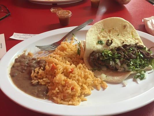 Steak taco with cilantro and onion, rice & beans