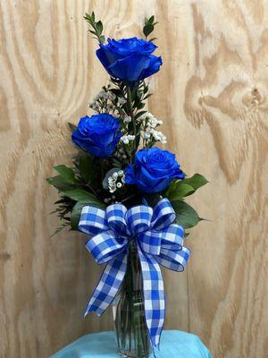 Blue Rose Trio arranged in a vase with greenery and filler.