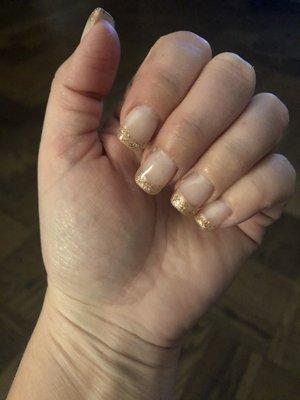 Gold glitter tips on gel nails.