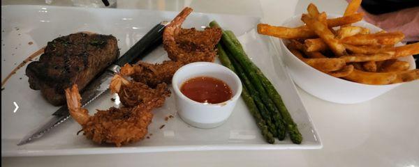 Steak and coconut shrimp asparagus, and fries