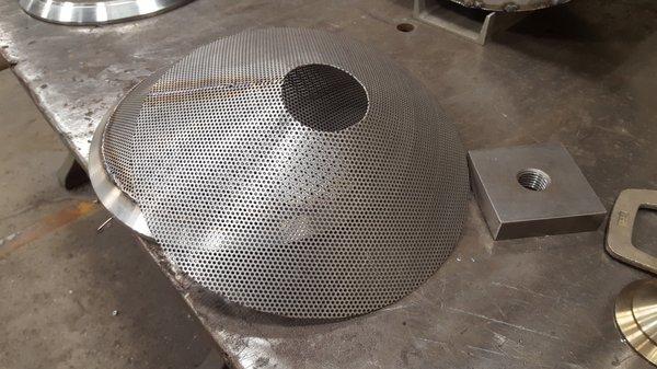 A perforated metal cone used for drying of parts at a local manufacturing plant.