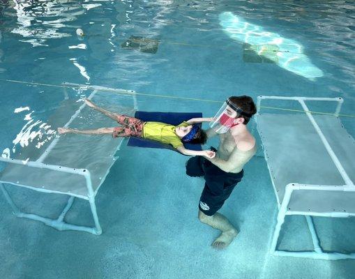 Student practicing a back float with the instructor.