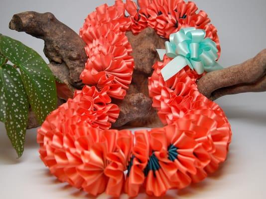 Coral and teal plumeria ribbon lei for graduation.