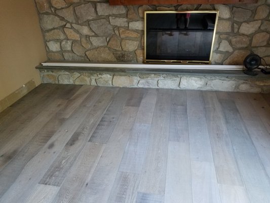 Engineered hardwood scribed at stone fireplace