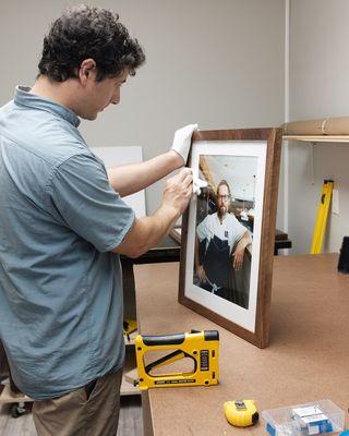 Cleaning a custom frame created with reclaimed barn wood that was milled, shaped and finished by the team at Cove Creative.